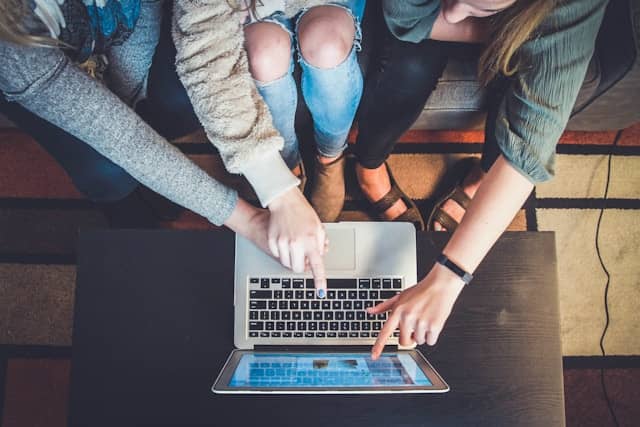 students are studying together on a laptop 