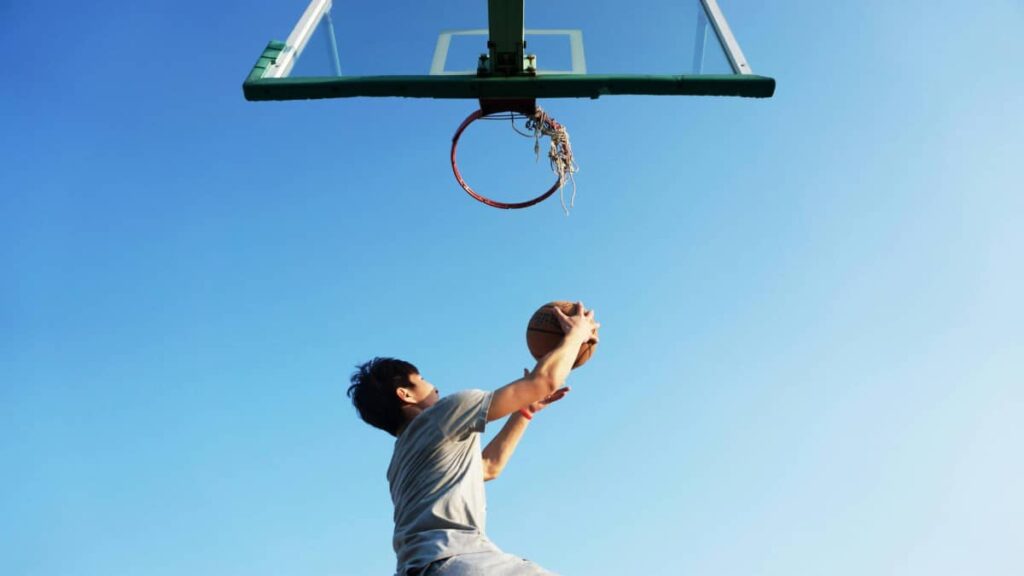 Man playing basketball and net is broken 